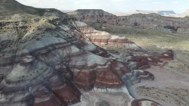 Cinematic 11-second drone footage featuring a smooth sideways tracking shot along the vibrant Bentonite Hills in Utah. Shot at a high frame rate of 60fps, allowing for perfect slow-motion editing.