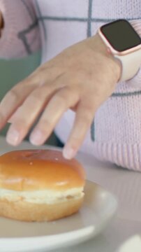 Vertical video: Placing left-hand bun, hands pressing, opening buns at counter for lunch, pink top