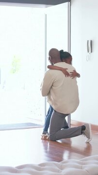 Vertical video: Opening front door, father kneeling hugging daughter coming home, placing backpack