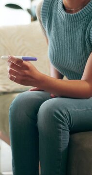 Stress, pregnancy test and hands of woman on sofa in home with regret or mistake for unplanned maternity. Anxiety, scared and female person with positive result for failed birth control in house.