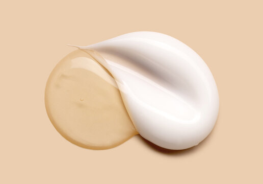 cosmetic smears of creamy texture on a pastel beige background