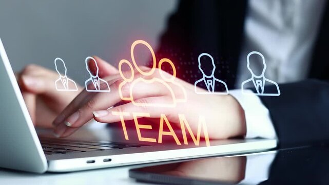 Hands typing on laptop with team icons and text during a work session in an office setting.
