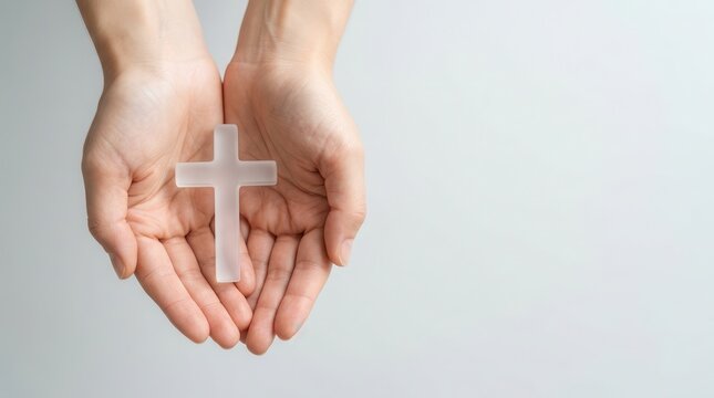 Hands holding a white cross for Easter worship and prayer concept.