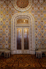 Obraz premium Ornate Arab Room inside Palacio da Bolsa in Porto featuring intricate decorative ceiling carved arches columns and geometric wooden floor. Famous interior and architectural masterpiece in Portugal.