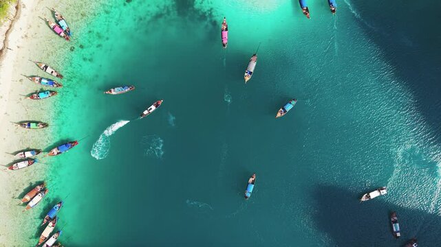 Top down aerial view of traditional longtail boats floating on the crystal clear turquoise water of Maya Bay, Koh Phi Phi Leh, Thailand