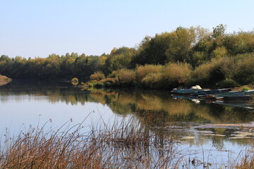 Fototapeta premium boats near the river bank on a sunny evening in late summer