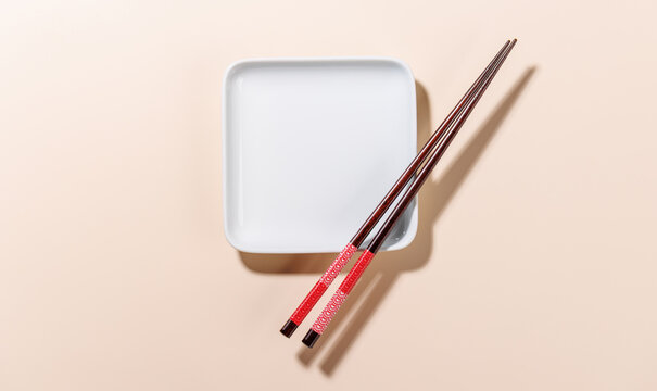 Minimal Sushi Plate with Chopsticks on Beige Background