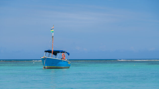 blue boat on turquoise sea in minimalist seascape