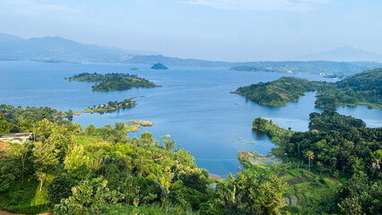 Fototapeta premium Aerial view of the beautiful lake and green islands with mountain natural landscape at sunrise. Famous Jatigede reservoir West Java, Indonesia.