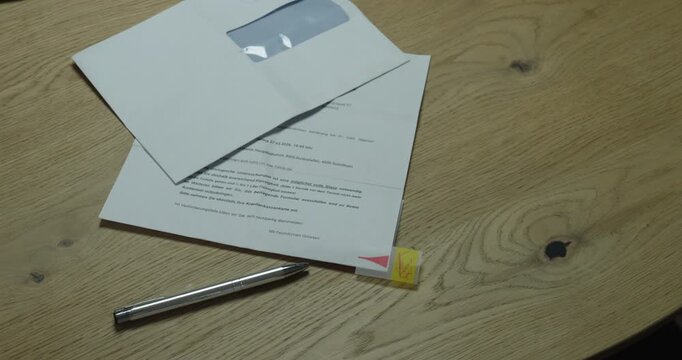 Hands marking the signature area with a sticky tab and signing a document. Concept of contract preparation, agreement, and official paperwork process.
