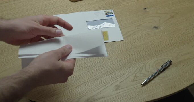 Hands marking signature fields on a document with sticky tabs and placing it into an envelope. Concept of contract preparation, signing guidance, and official document mailing.