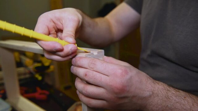 The craftsman applies putty to wood