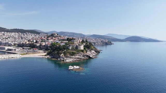 Aerial footage of a coastal town built on a rocky peninsula with sea and harbor surroundings.