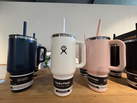 Mallorca, spain, april 20, 2026, hydro flask carry out tumblers with handles and straws displaying hydration on rustic wooden shelf