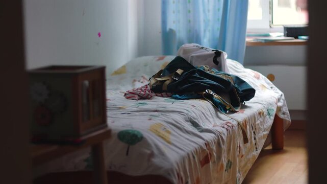 Child bedroom with school backpack placed on bed ready for day ahead suggesting routine preparation daily life and quiet morning atmosphere in home environment