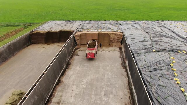 Aerial close approach to farm machine in silage pit