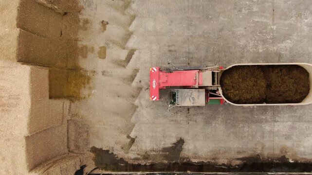 Aerial view of farm vehicle exiting silage storage
