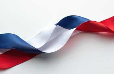 Fototapeta premium Fabric ribbon curves in blue white and red. Wavy material shows French flag colors. Smooth satin texture on isolated white background. Decoration for national events celebrations holidays.