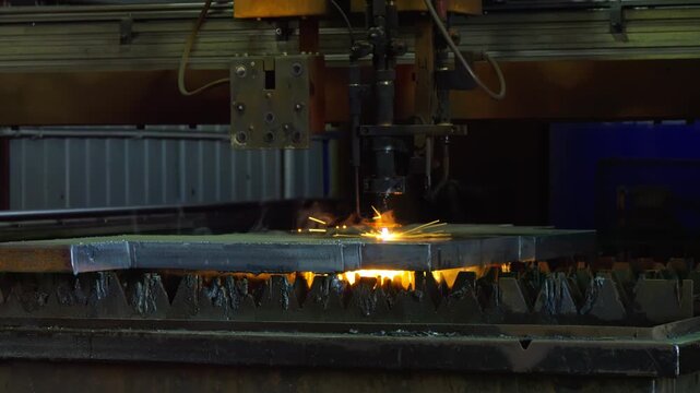 CNC plasma cutter engraving line across steel plate