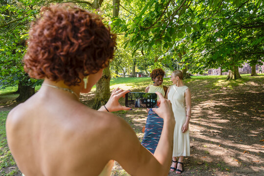 Woman photographing diverse happy friends sharing memory