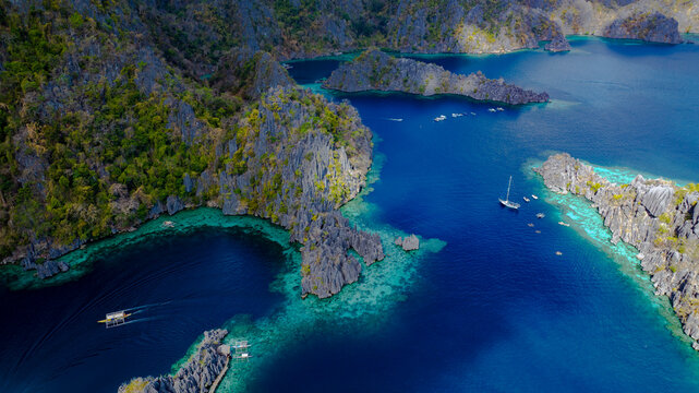 Aerial view of a beautiful tropical island with crystal clear water with limestone cliffs as the beach, Coron, Palawan, Philippines.
