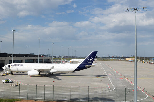 Airport Frankfurt am Main, Germany, April 11, 2026. - Lufthansa airplane on the airfield of Terminal 3. Handling area for passenger aircraft. Blue sky with clouds in the background.