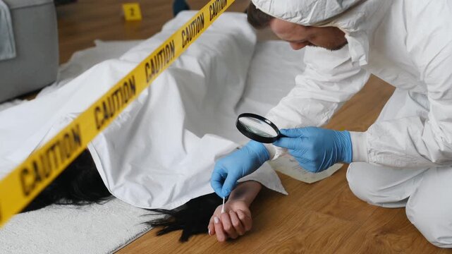 Forensic expert in protective gear examines evidence at a murder scene with a body covered in a white sheet and caution tape marking the area