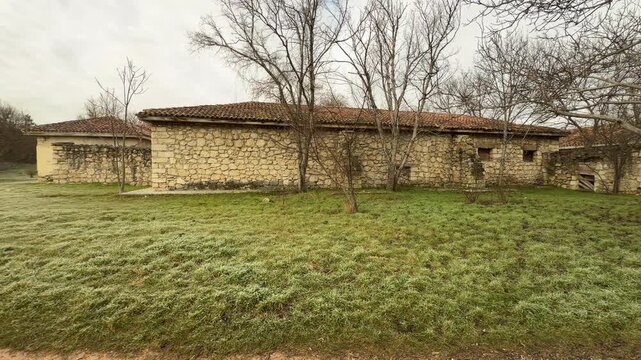 Ancient limestone structures sit peacefully among leafless trees on a frost-covered lawn. The scene feels cold yet nostalgic, reflecting the enduring spirit of Crimean history.