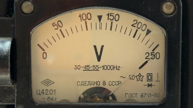 An analog voltmeter needle fluctuates as electricity flows through the internal coils. This electrical regulation produces a steady, low-frequency hum and a faint mechanical vibration.