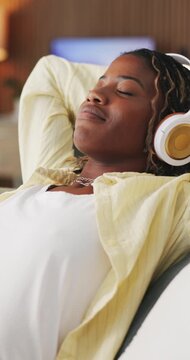 Relax, smile and black woman with headphones on couch, mindfulness audio guide and streaming music. Rest, listen and happy person with meditation track for stress relief, stretching and tech in home