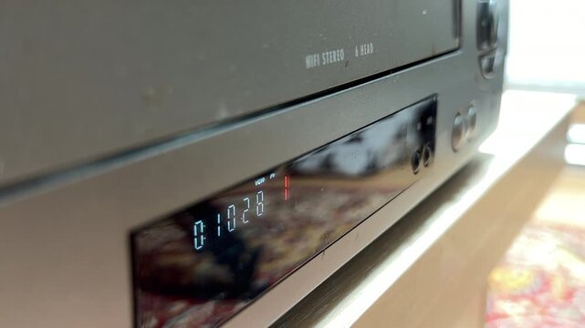 The VCR stops the spinning tape and engages the ejection motor. This sequence produces a series of mechanical whirring sounds, rhythmic gear clicks, and a solid thud as the cassette is pushed out.