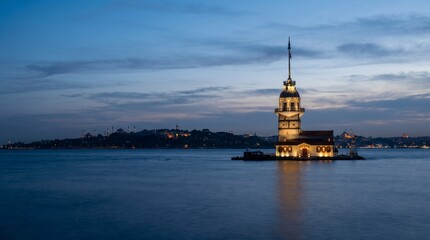 Obraz premium Maiden's Tower illuminated at dusk by the sea in Istanbul 