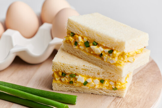 Tamago sando, Japanese egg salad sandwich, on a light background.