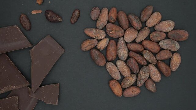 Broken Chocolate Bar and Cocoa Beans on a Black Background. Farm to Bar Chocolate. Top View. Minimal.