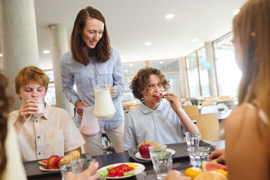School lunch experience with children eating healthy meals in bright cafeteria
