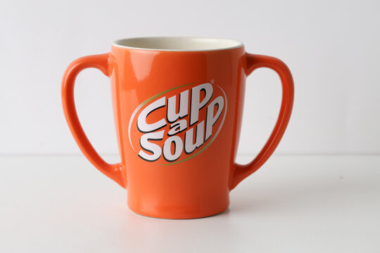 The Hague, Netherlands - March 29, 2026: Cup-a-Soup Mug - Bright Orange Ceramic Cup with Dual Handles on White
