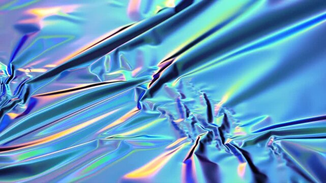 Slow pan tracking closeup of iridescent metallic foil rippling and folding across crumpled sheet on tabletop studio macro surface