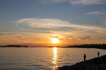 Obraz premium Istanbul Kartal Coast Sunset with Fishermen Silhouettes, Sea of Marmara and Princes Islands, Turkey
