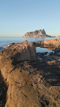 Drone flying low over rocky coastline towards pe&ntilde;&oacute;n de ifach