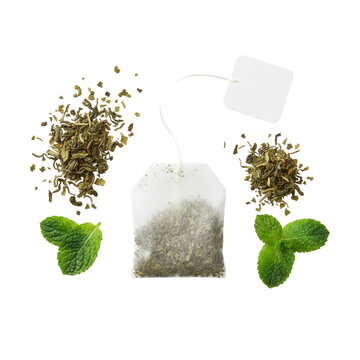 Extreme macro flat lay of a detailed paper teabag with dried green tea leaves, string, blank tag, loose leaves, and fresh mint on a transparent background, concept of natural wellness