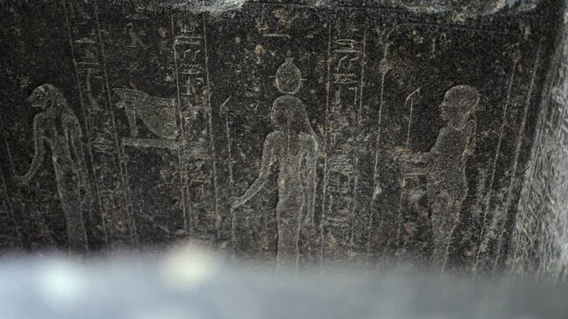 Ancient egyptian hieroglyphs, deities, and pharaohs carved in black stone, a closeup detail of an old civilization's writing system and religious art from egypt