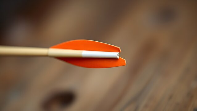 A single arrow nocked on a bowstring, focus on the arrowhead.