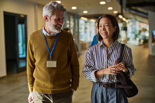 Business colleagues walking and talking in office hallway