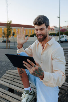 Man waving hello during video call on tablet
