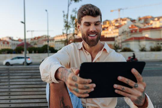 Digital nomad man using tablet outdoors in Lisbon