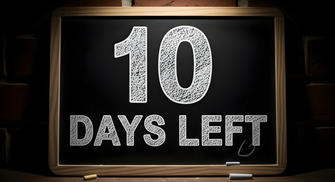 Blackboard with 10 days left written on it in white chalk, sitting on a desk with chalks, against a brick wall background