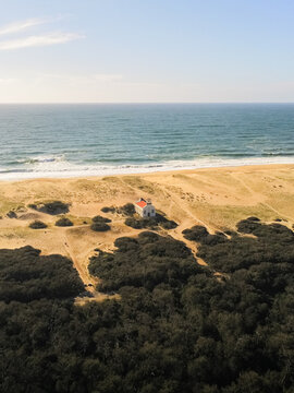 Aerial view of Chapelle Sainte-Therese with its red roof nestled in the sand dunes along the Atlantic coast in Labenne, Nouvelle-Aquitaine, France.