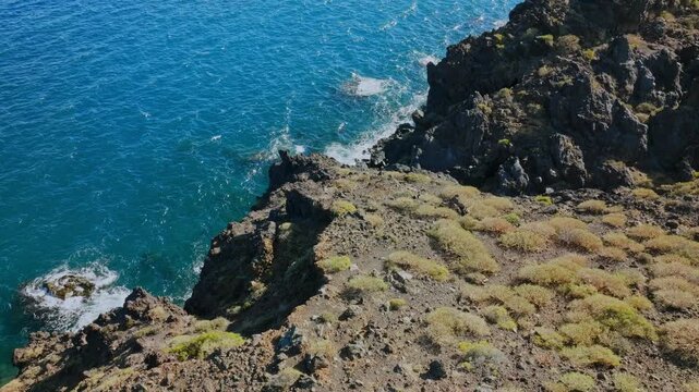 A rugged coastal volcanic cliff that drops into blue Atlantic Ocean, Tenerife, Candelaria