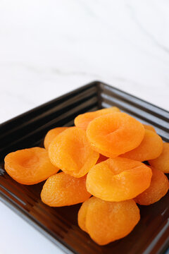 Dried apricots isolated on white background with copy space. Sun-dried golden organic apricots, natural healthy snack rich in nutrients, vibrant color and texture, ideal for food concepts.
