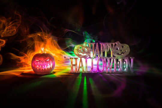 Halloween concept. Creepy silhouette in the dark corridor with pumpkin head. Toned light with fog on background.
